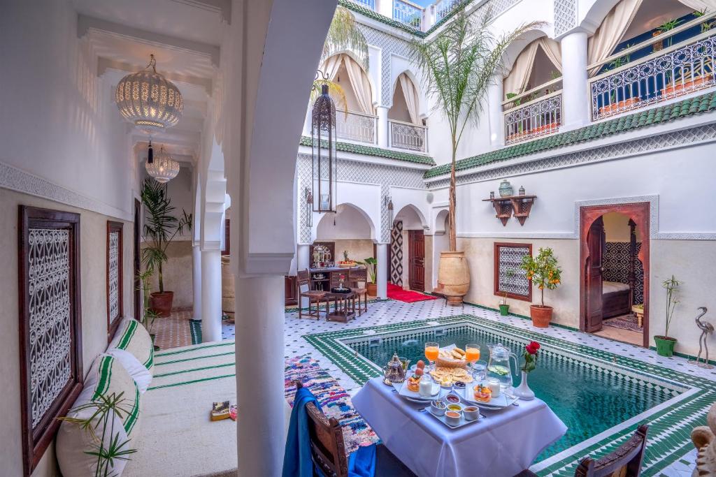 uma piscina interior com uma mesa no meio de um edifício em Riad Al Madina Marrakech & Spa em Marraquexe
