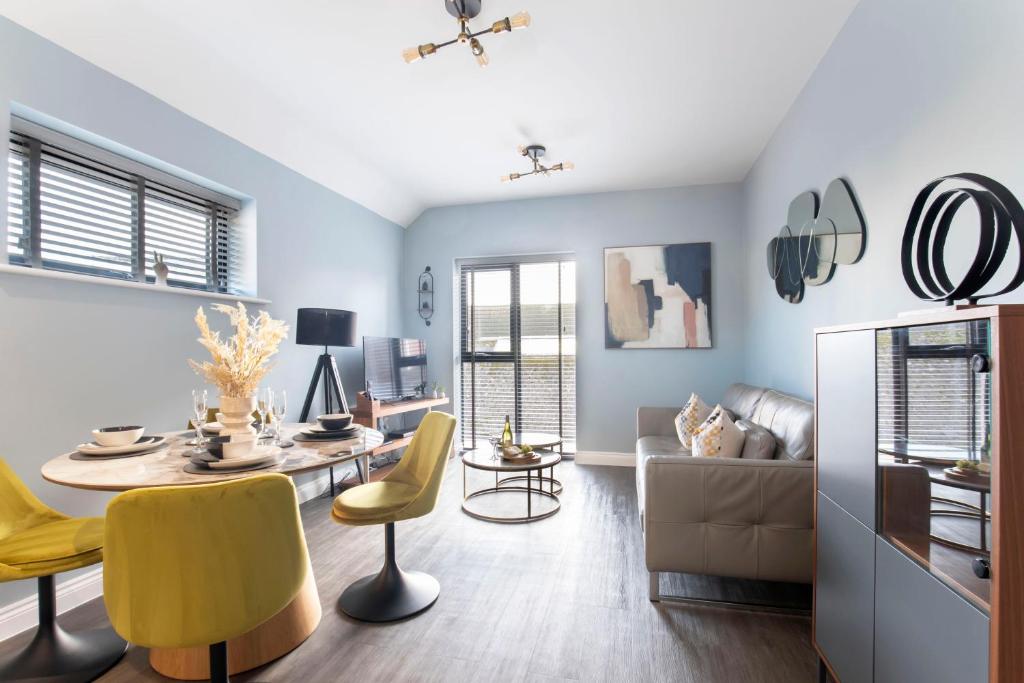 a living room with a table and yellow chairs at Elliot Oliver - Luxurious Two Bedroom Apartment in The Docks in Gloucester