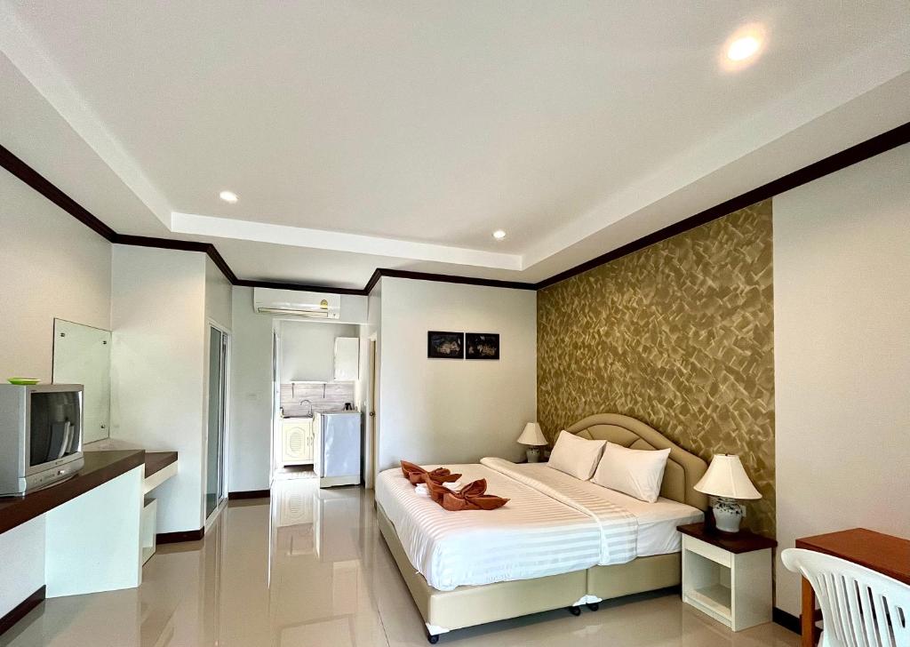 a bedroom with a large bed and a television at Tan Residence in Ko Lanta