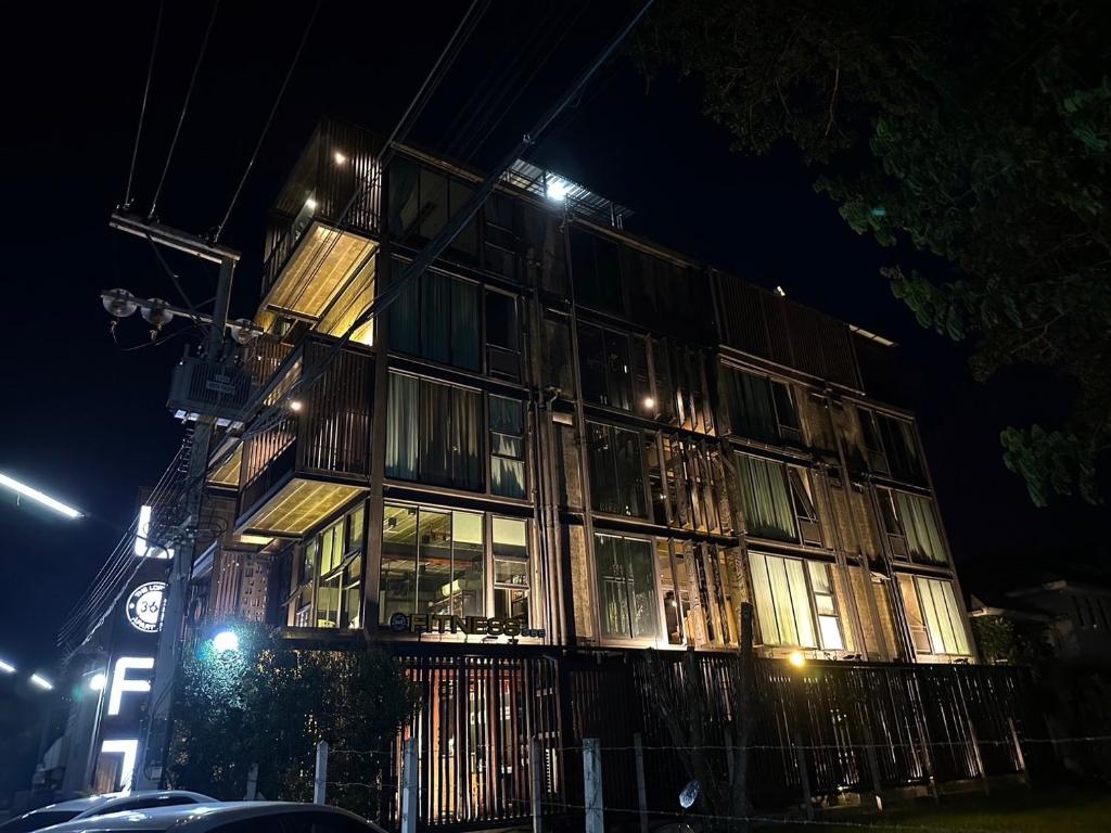 un edificio con muchas ventanas por la noche en The Loft Bar365, en Buriram