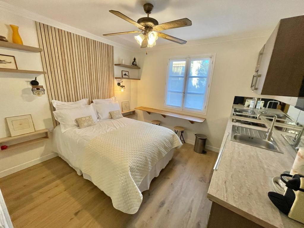 Il comprend une chambre avec un lit et une cuisine avec un ventilateur de plafond. dans l'établissement Cozy Studio on Bd Croisette-AC- BeachesCongress by Olidesi, à Cannes