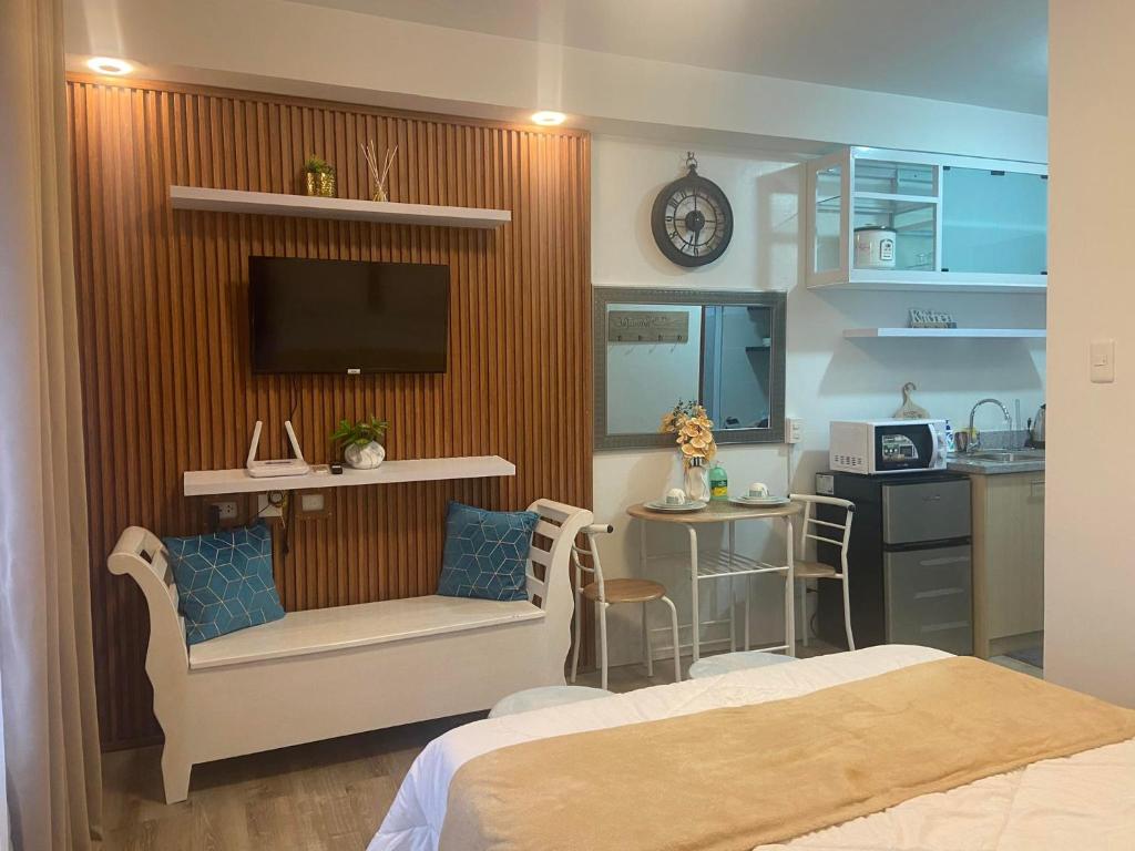une chambre avec un lit et une cuisine avec une télévision dans l'établissement Jeiden Suites Bacolod, à Bacolod