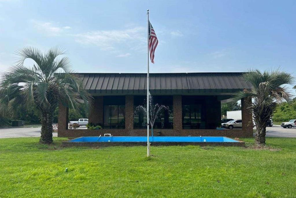 a flag in the grass in front of a building at Days Inn by Wyndham St George in Saint George