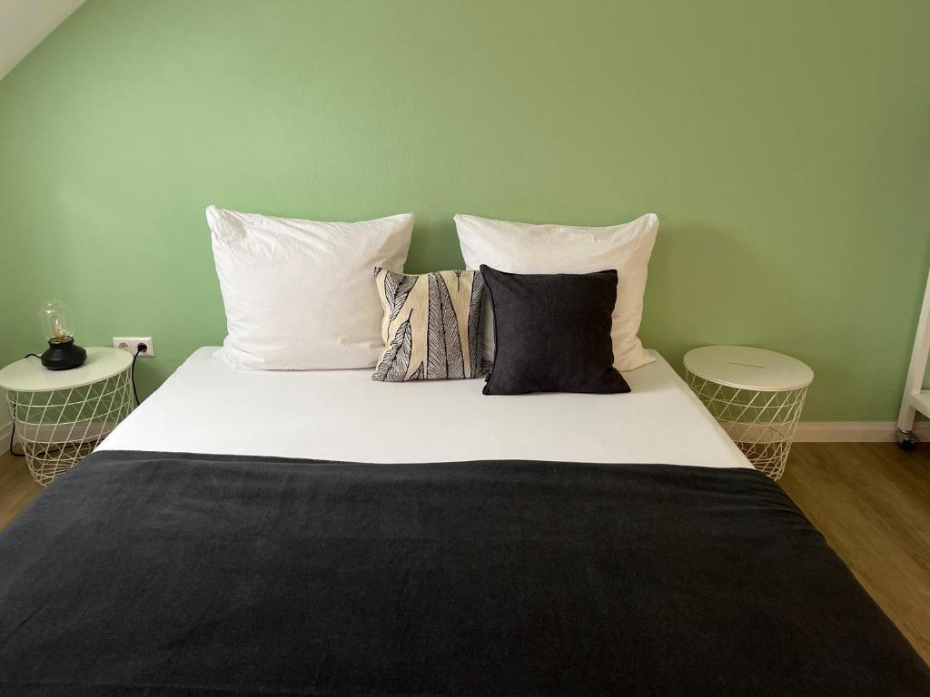 uma cama grande com lençóis brancos e almofadas em Stadtstudio Saarlouis em Saarlouis