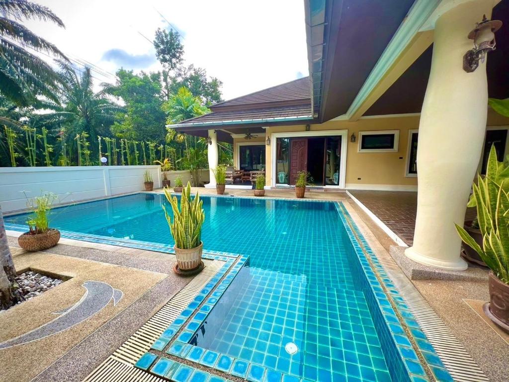a swimming pool in front of a house at Grand Villa Khaolak in Khao Lak