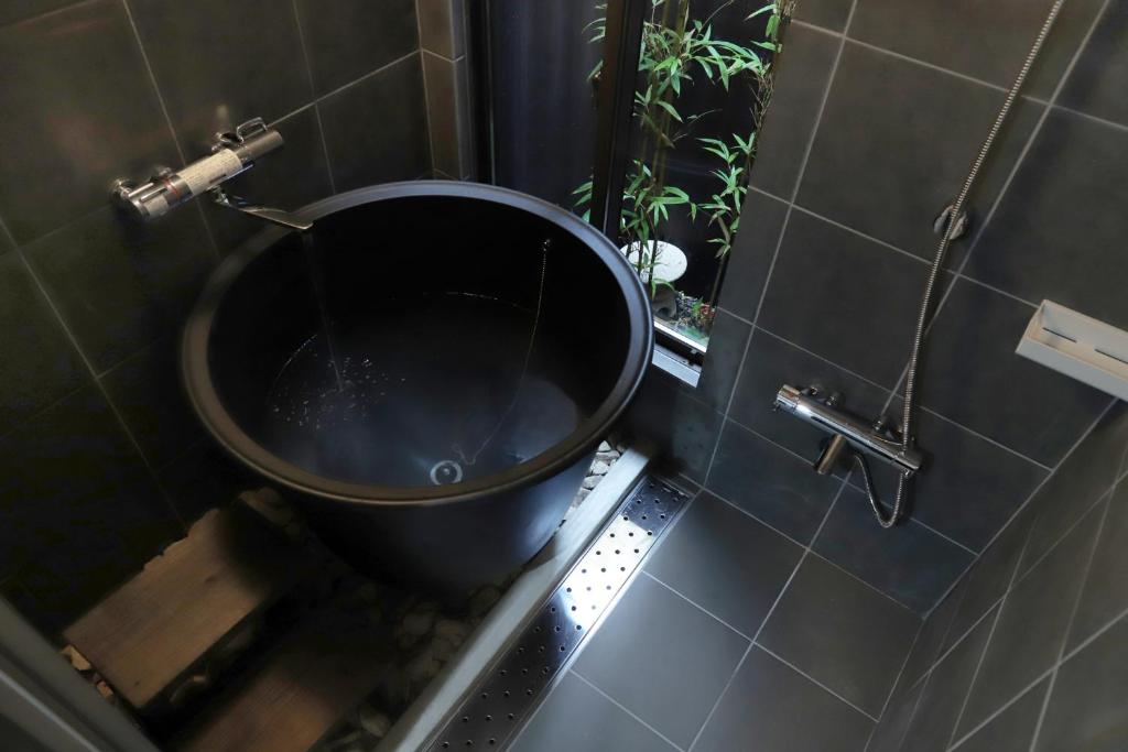 een badkamer met een zwart toilet in een douche bij Samurai tei in Kyoto