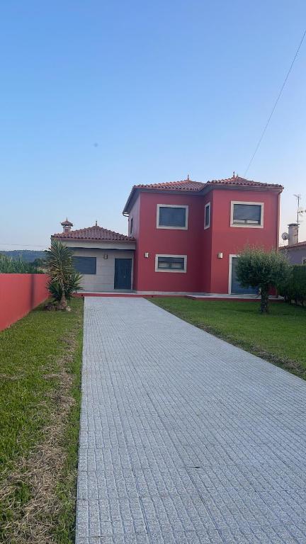 una casa roja con un camino de ladrillo delante de ella en Casa Da Estrada Velha, en Medonha