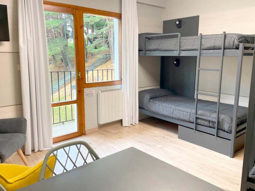 フォルミガルにあるApartamentos Midi 3000の二段ベッドとテーブルが備わる小さな客室です。