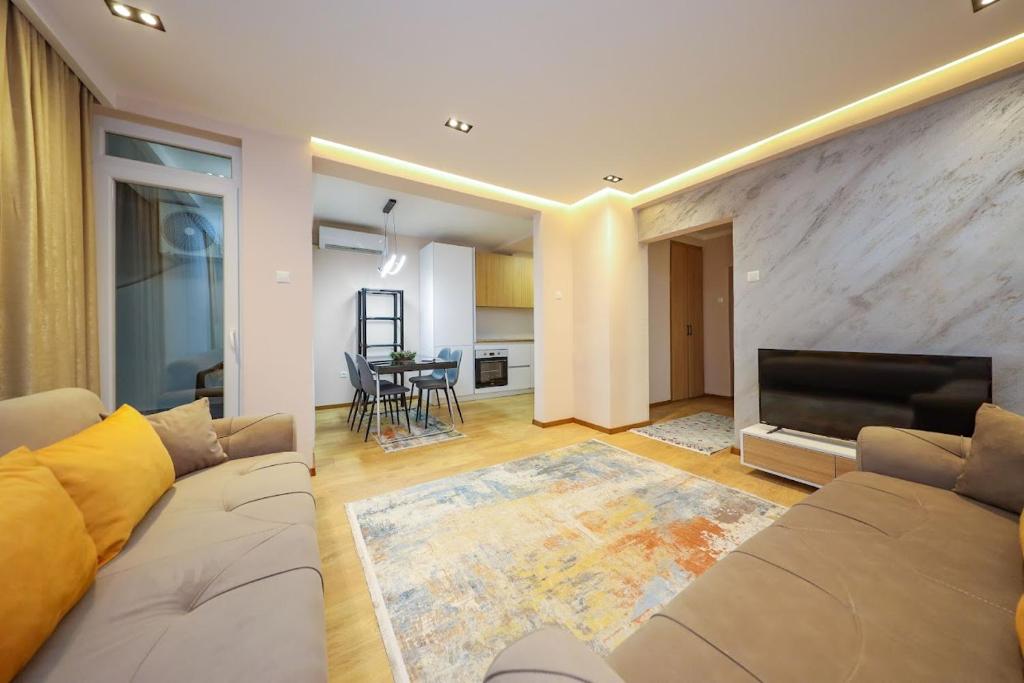 a living room with a couch and a flat screen tv at Apartment Alpi in Peje