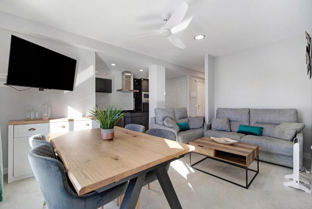 sala de estar con mesa de madera y cocina en Refugio del mar, en El Puerto de Santa María