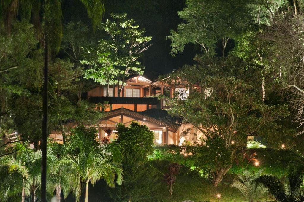 a house in the forest at night at Pousada Les Roches in Itaipava