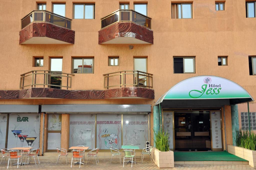 a building with tables and chairs in front of it at Jess Hotel in Atigan