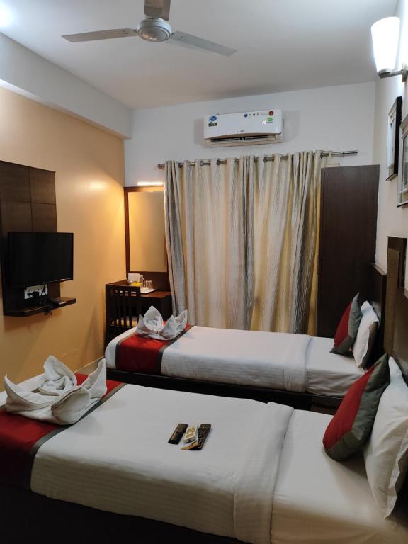 Postel nebo postele na pokoji v ubytování SKY GATE HOTEL Near Apollo MAIN, Women's & Children's US Consulate Sankara Netralaya Goethe Institute PrestigePalladium Shastri Bhavan Senmozhi Poonga Raj Ratnam Stadium TAJ Coromandal India Oil Bhavan Dr Mohan's Diabetics VAC Chennai