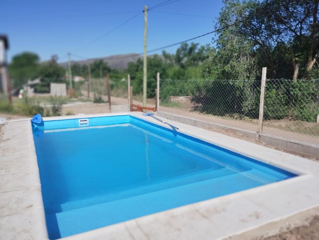 una piscina azul en la parte superior de una casa en Mecohue en Villa Giardino