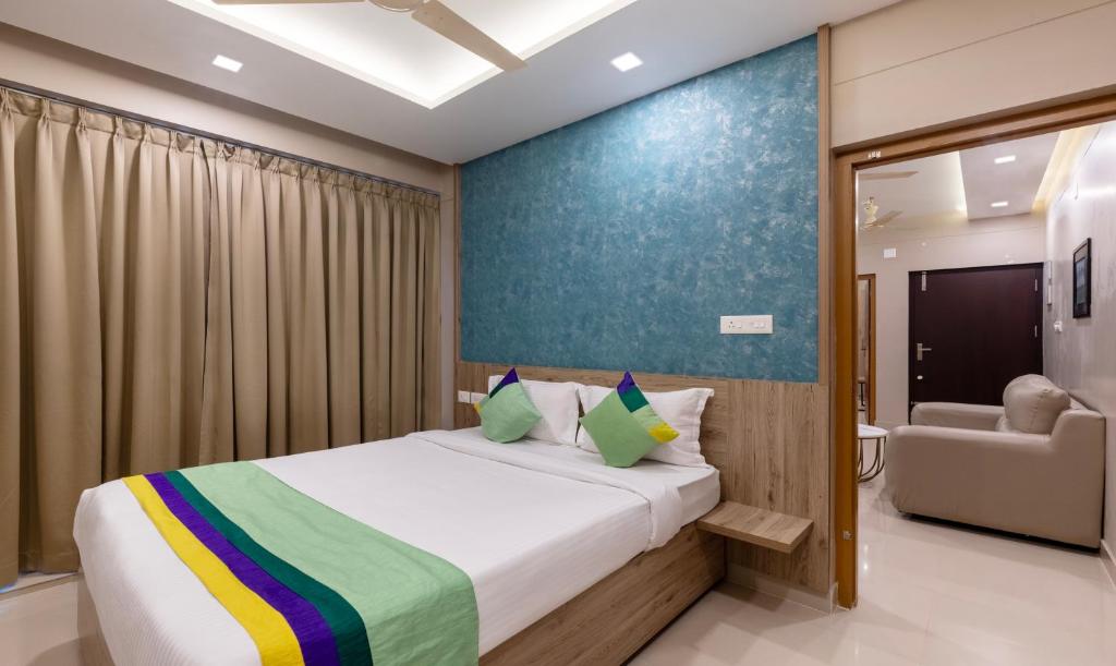 a bedroom with a bed and a couch in a room at Treebo Trend Sreepathi Prayag Apartments in Guruvāyūr