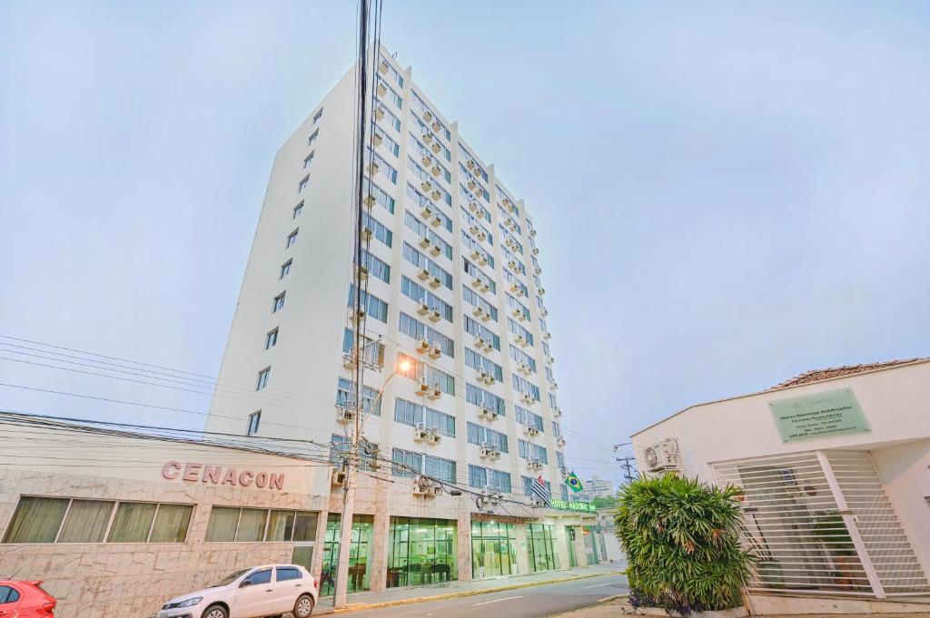 a tall white building with a car parked in front of it at Hotel Nacional Inn Piracicaba in Piracicaba