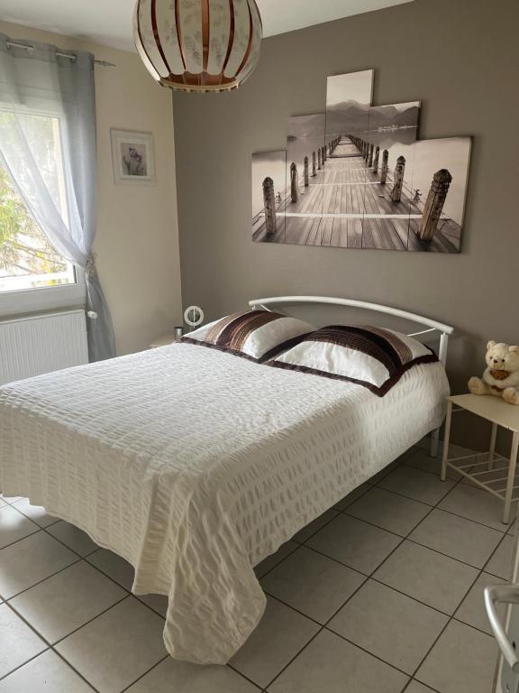 1 dormitorio con 1 cama y una foto de un muelle en Charmante et agréable chambre dans une villa calme, en Andrézieux-Bouthéon