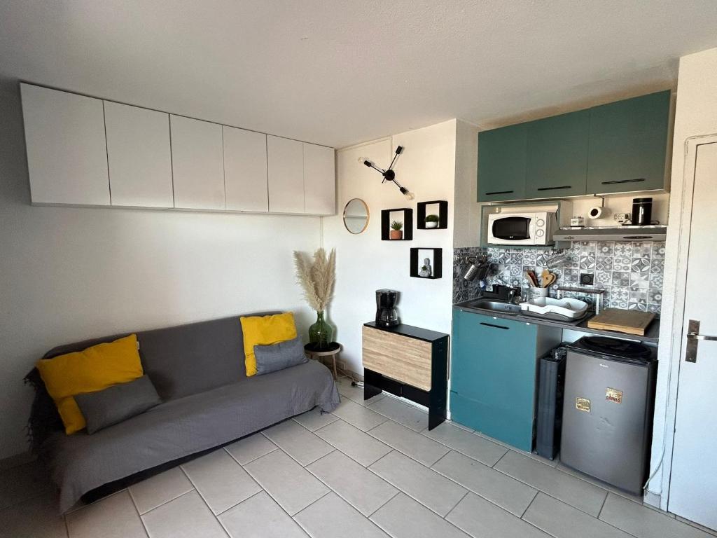 sala de estar con sofá y cocina en Studio 200m de la plage Le Barcares en Le Barcarès