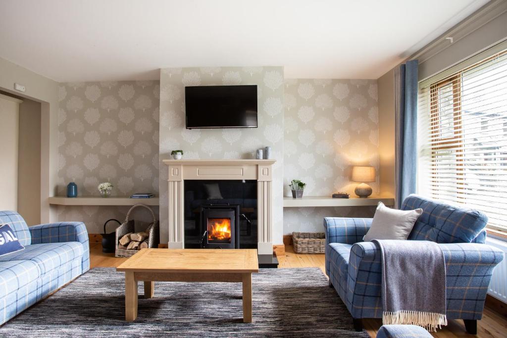 a living room with a couch and a fireplace at Donegal Boardwalk Resort in Carrigart