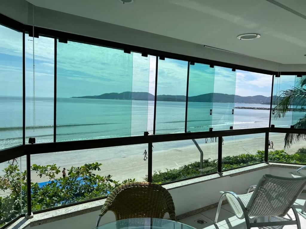 Habitación con ventanas y vistas a la playa. en Apartamento Frente Mar Meia Praia en Itapema