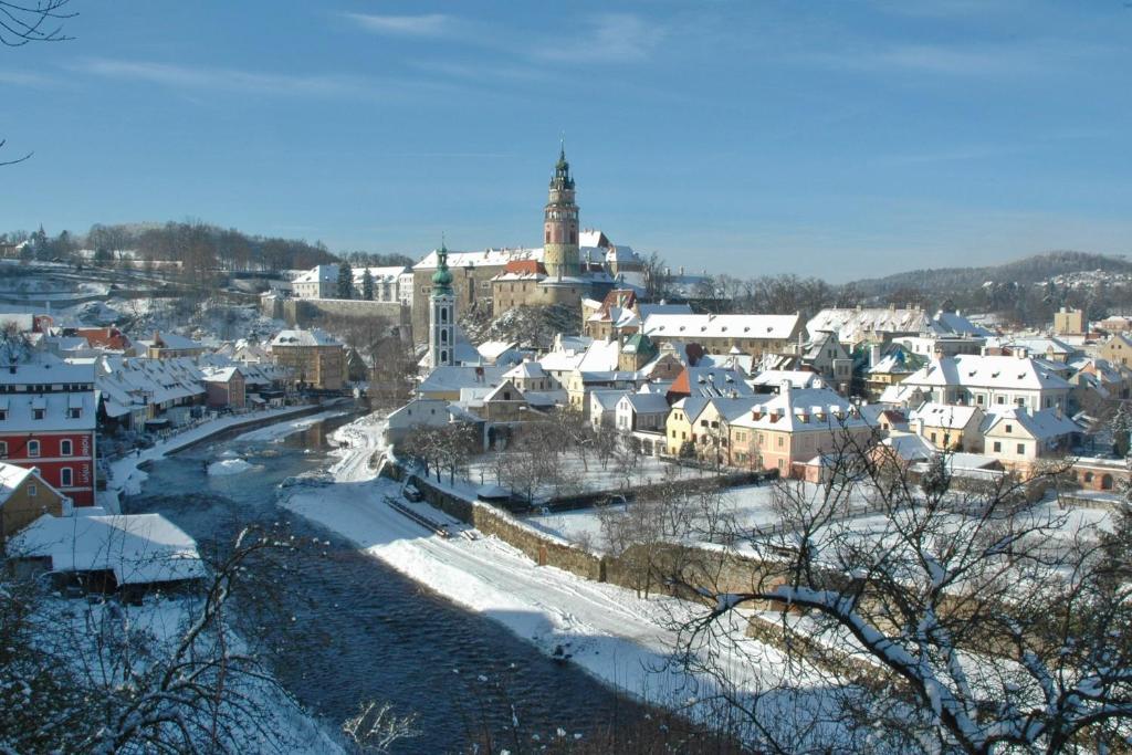 a city with snow covered buildings and a town at Hotel Leonardo in Český Krumlov