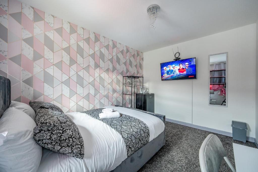 1 dormitorio con 1 cama y TV en la pared en RB27R For your most relaxed & Cosy stay Free Parking Free Fast WiFi, en Kirkstall