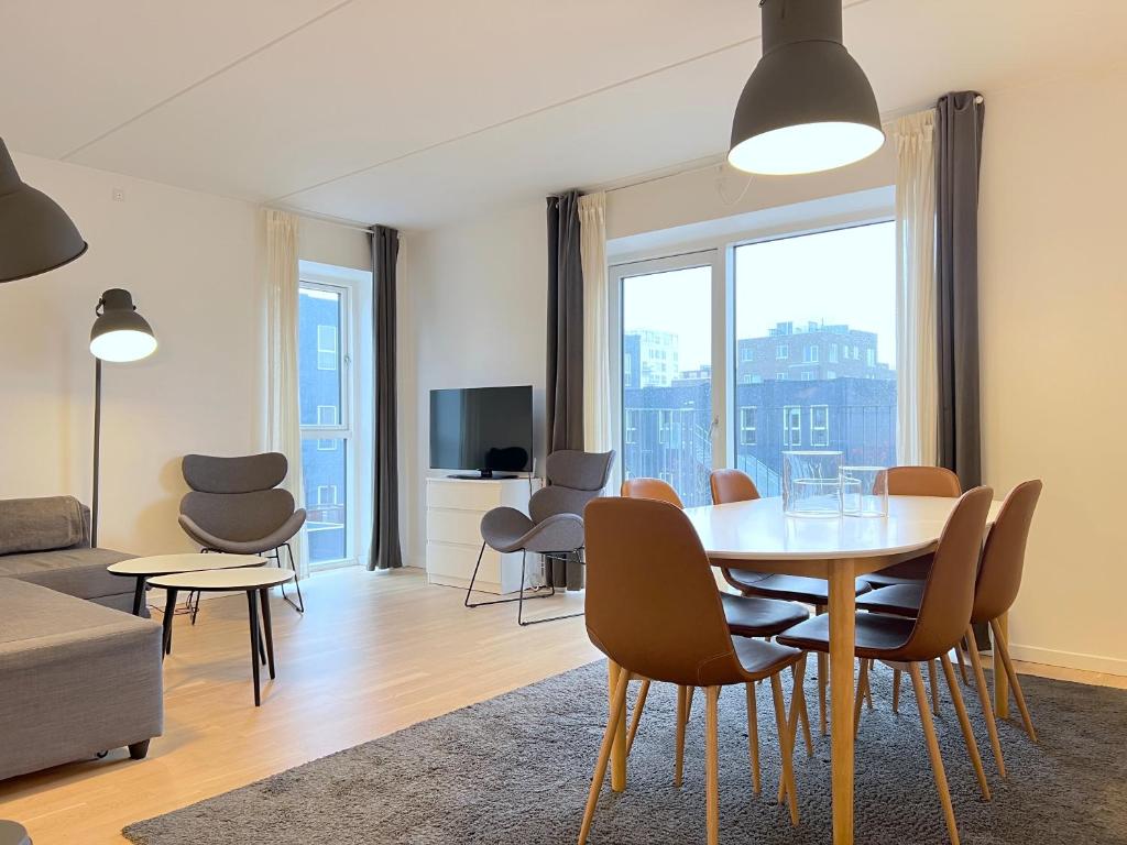 a living room with a table and chairs at Bright And Spacious 3 Bedroom Apt In Orestaden in Copenhagen