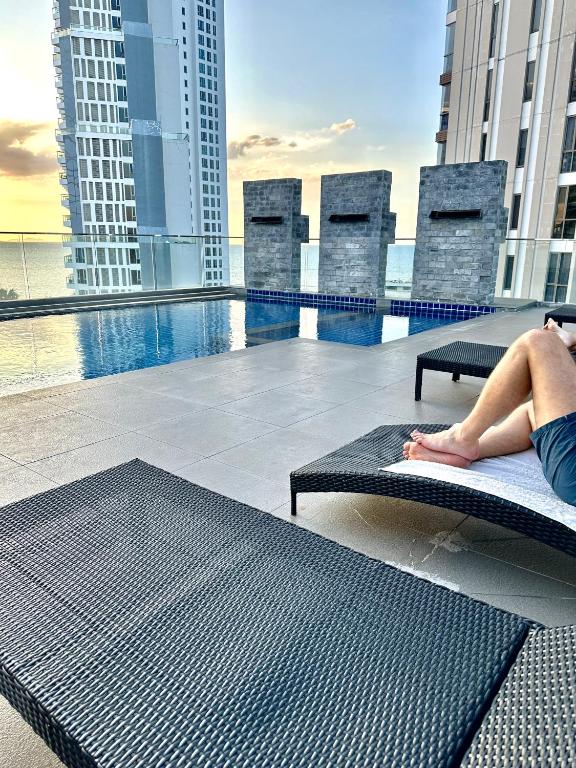 a woman laying on a bench on the roof of a building at Apartment Serenity Wongamat in North Pattaya