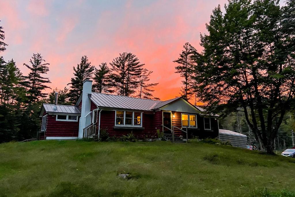 una pequeña casa en una colina con una puesta de sol en Woodland Cottage In the Mountains, 