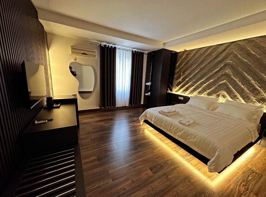 Pokój hotelowy z łóżkiem i biurkiem oraz łóżkiem o wymiarach sześciu sześciu sześciu. w obiekcie Tirana Central Rooms w Tiranie