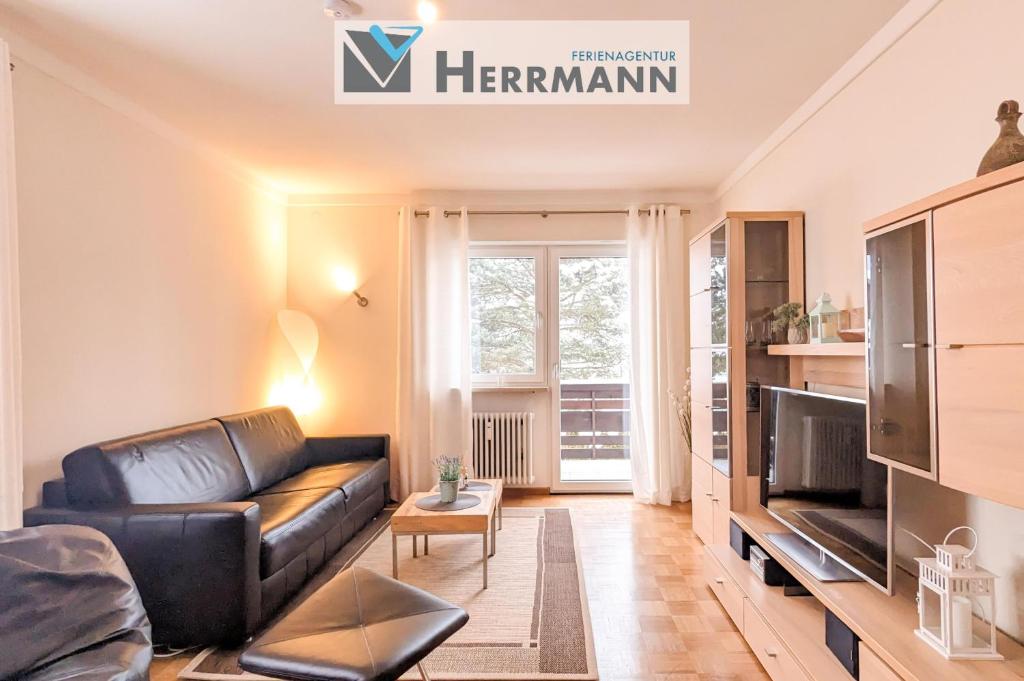 a living room with a leather couch and a tv at Ferienwohnung Foetibus in Füssen