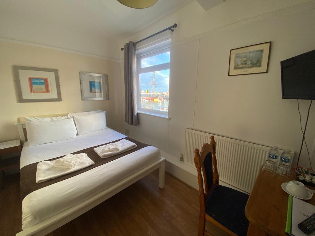 ein kleines Schlafzimmer mit einem Bett und einem Fenster in der Unterkunft Lady Hamilton Public House B&B in Portsmouth