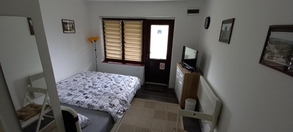 ein kleines Schlafzimmer mit einem Bett und einem Fenster in der Unterkunft Soba Tina in Vrdnik