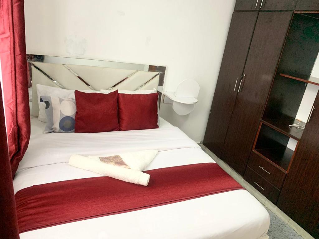 a bedroom with a bed with red and white pillows at Rorot Spacious one bedroom in Kapsoya with free Wifi in Eldoret