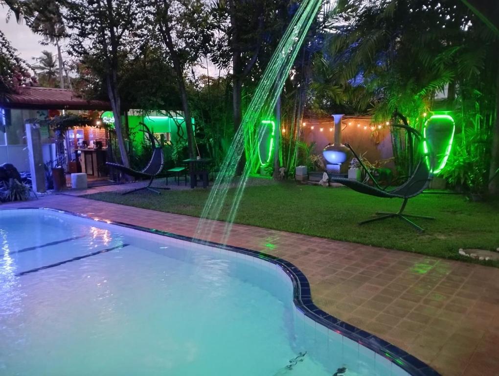 ein Pool mit einem Brunnen in einem Hinterhof in der Nacht in der Unterkunft Palms Villa in Negombo