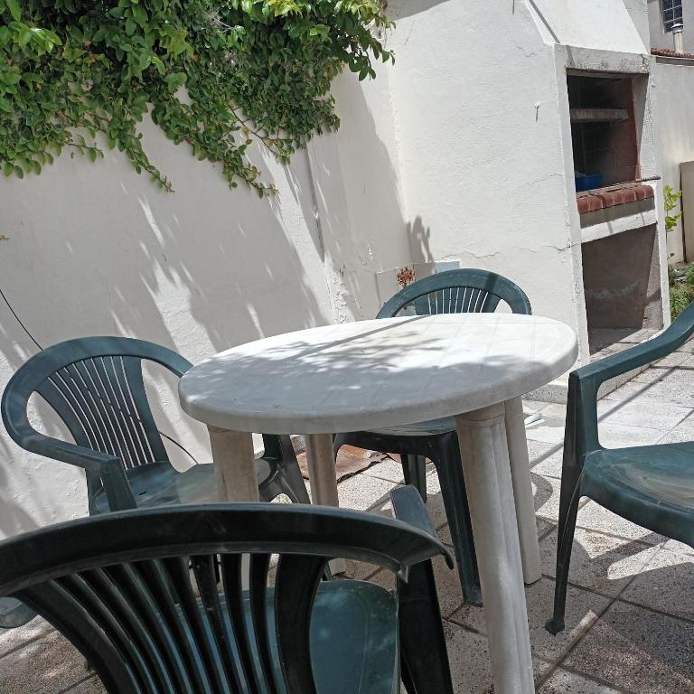 una mesa y sillas blancas junto a una mesa y sillas en La casa de piedra en Necochea