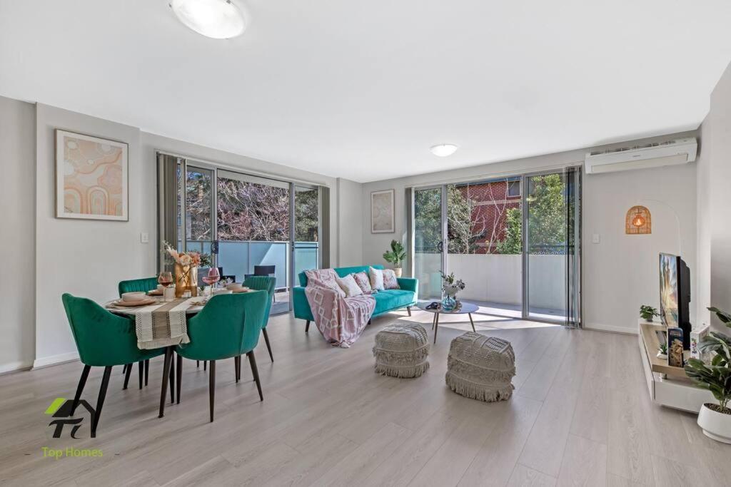 a living room with a table and green chairs at Entire apartment in Hornsby in Hornsby