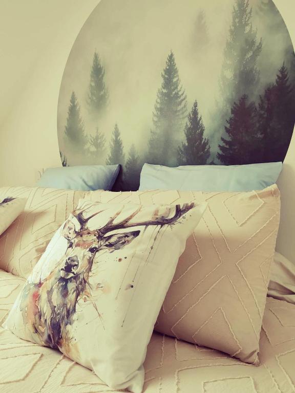 un lit avec une peinture de cerf sur lui dans l'établissement La Parenthèse, à Betton