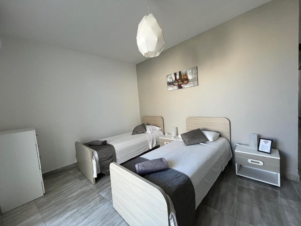 um quarto de hotel com duas camas e uma mesa em F7 Modern and Bright Apartment in Malta em Msida