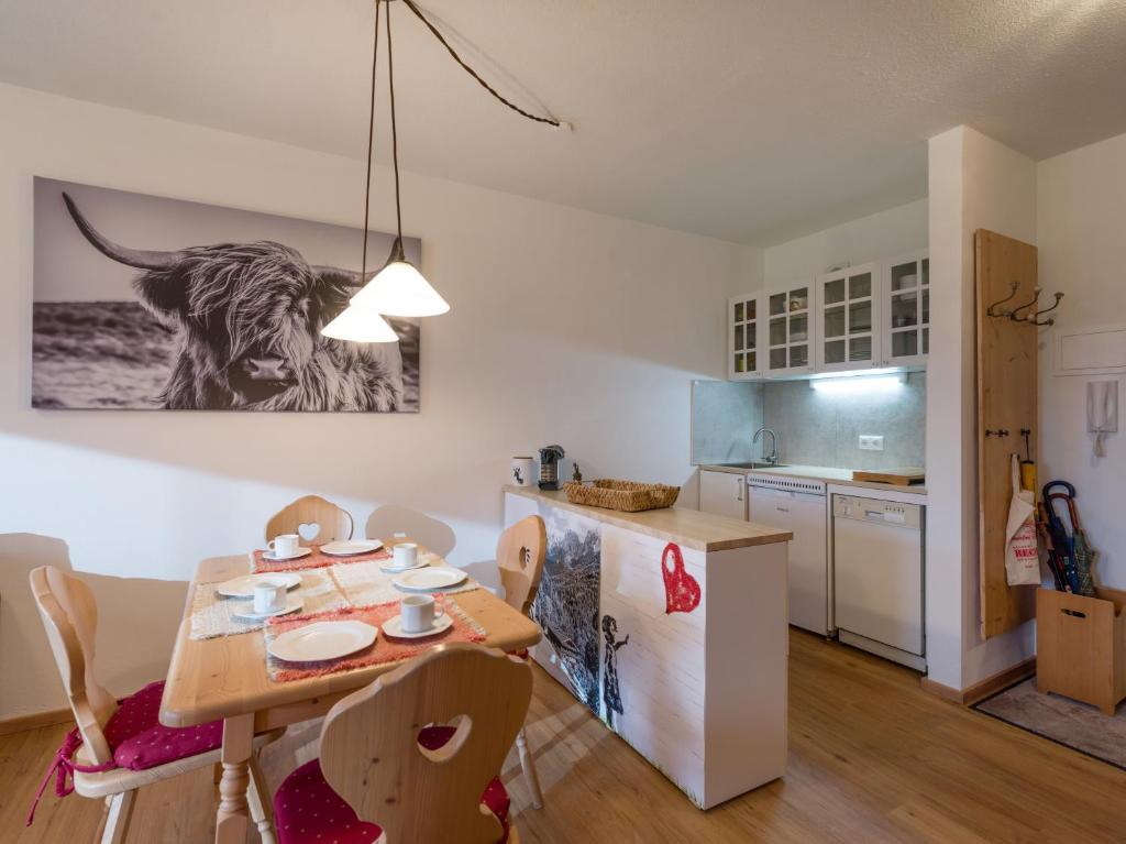Una cocina y un comedor con mesa y sillas. en Erdgeschosswohnung 8 im Bergschlössl, en Oberaudorf