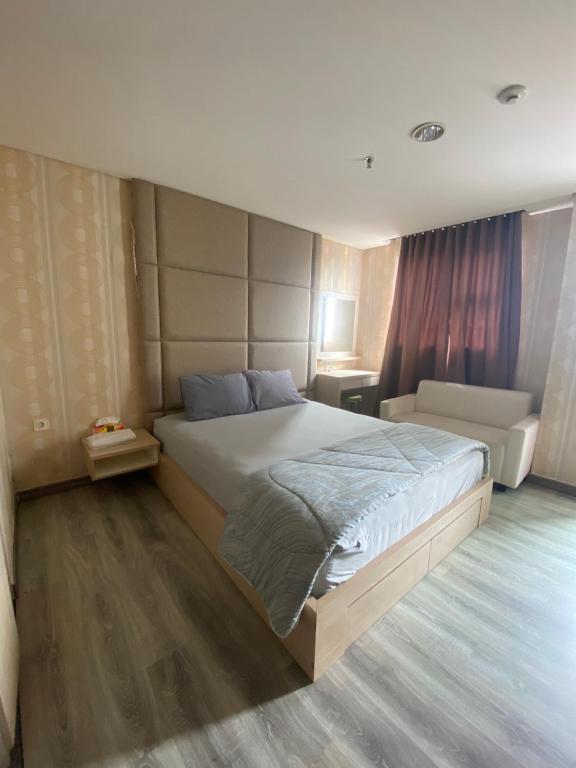um quarto com uma cama grande e um sofá em apartemen bintaro icon em Pondokaren
