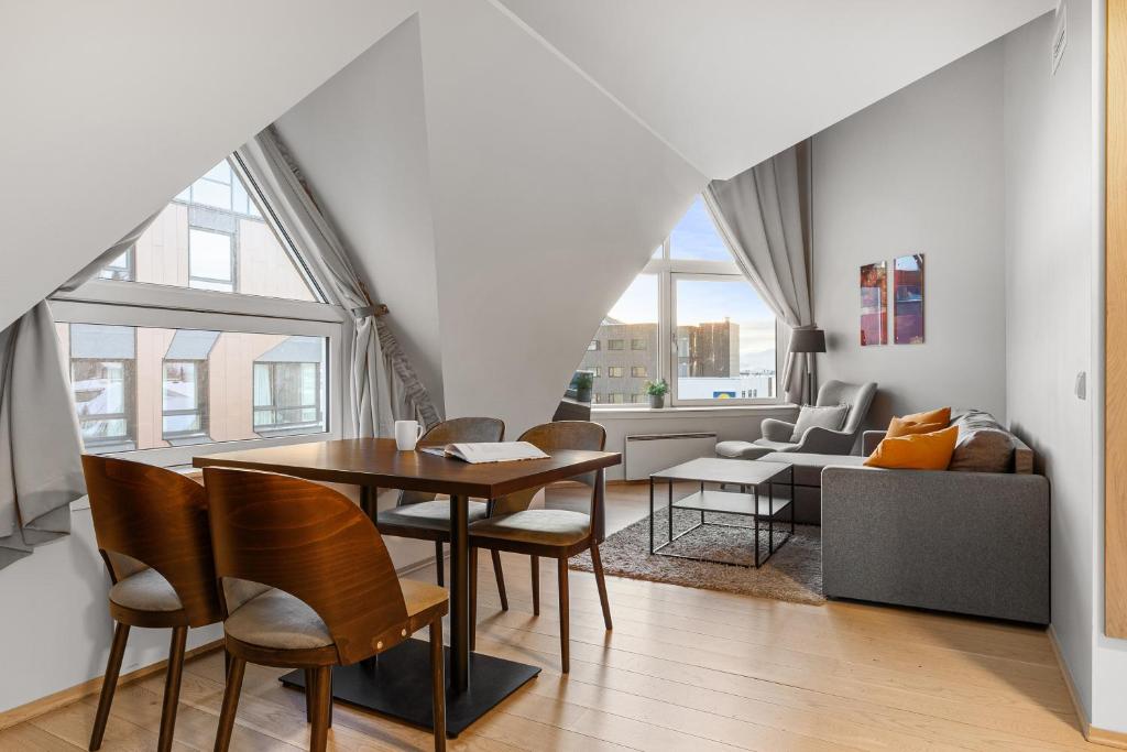 a dining room and living room with a table and chairs at Enter City Apartment Hotel in Tromsø