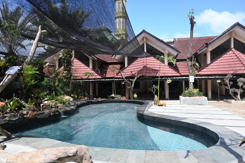 a swimming pool in front of a house at Rimbawan Guest House in Lampung