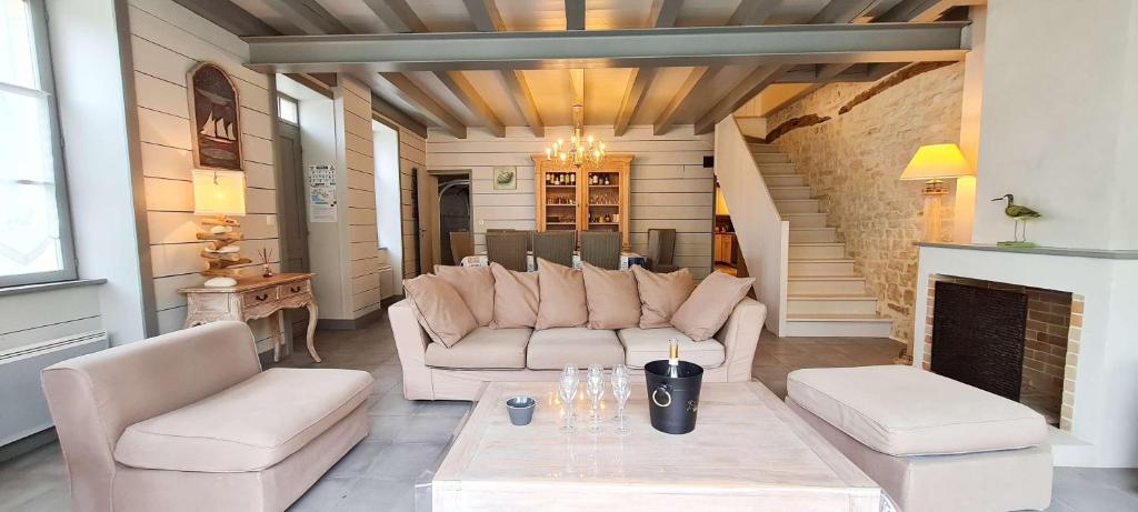 a living room with white furniture and a fireplace at Magnifique maison de village rhétaise in Sainte-Marie-de-Ré