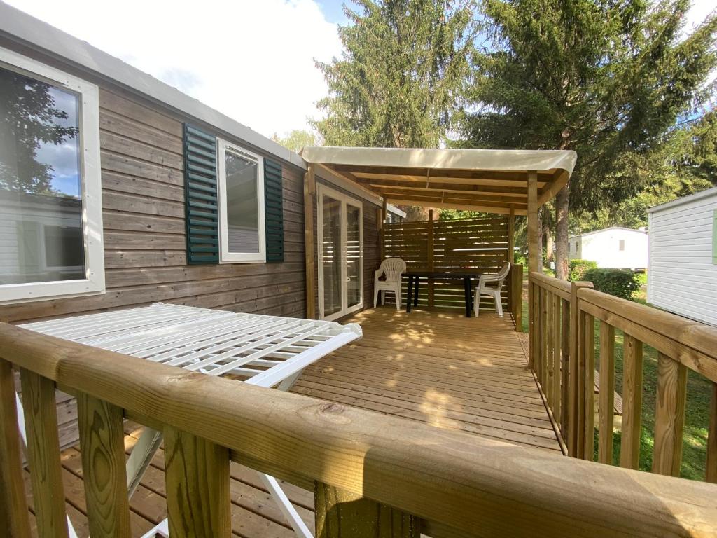 a wooden deck with a table and a bench on it at MOBIL HOME Clim BOOFZHEIM 6 PERSONNES 3 CHAMBRES LE RIED 3 ETOILES PROCHE EUROPA PARK in Boofzheim