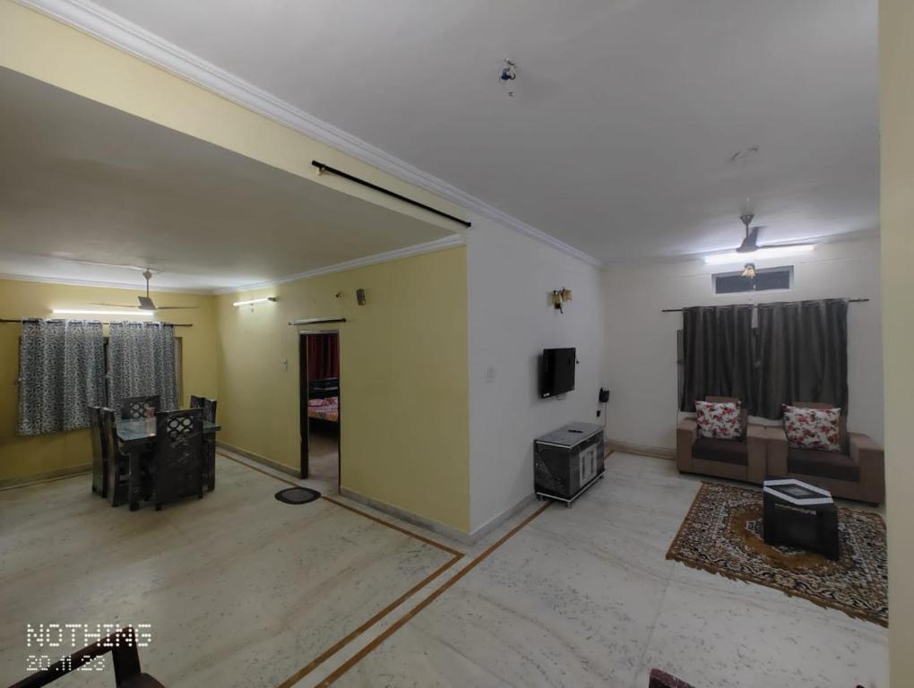 S A Villa في حيدر أباد: غرفة معيشة كبيرة مع تلفزيون وكراسي