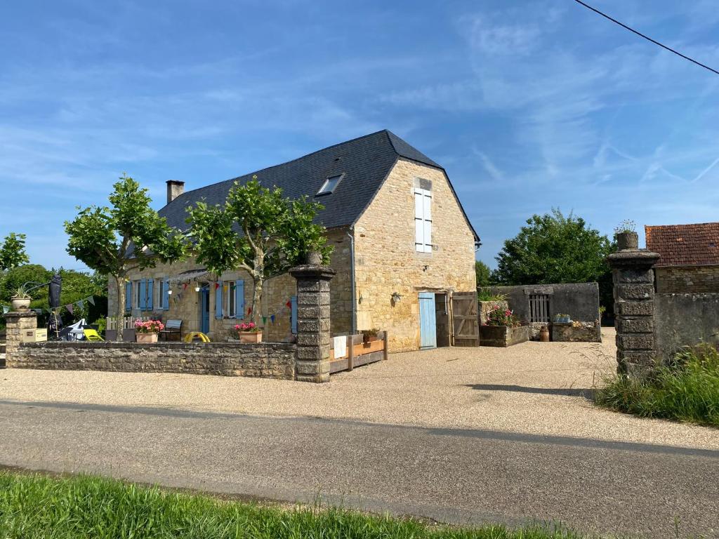 ein altes Backsteinhaus mit Auffahrt in der Unterkunft Gîte La Mauratie in Jayac