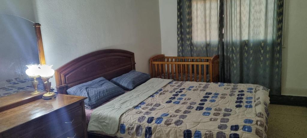 a bedroom with a bed and a desk with a lamp at appartement adam in Oujda