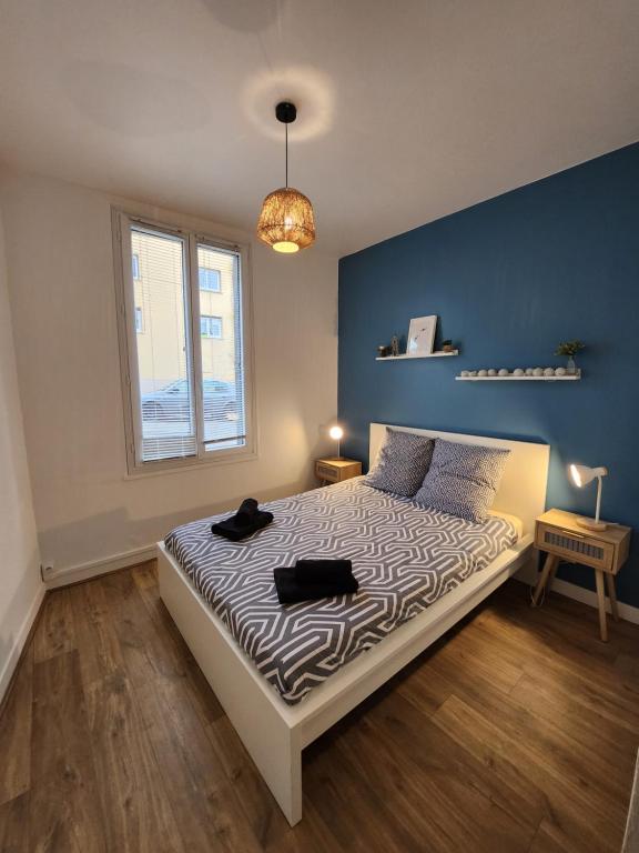 1 dormitorio con 1 cama con pared azul en Détente en centre-ville, en Rouen