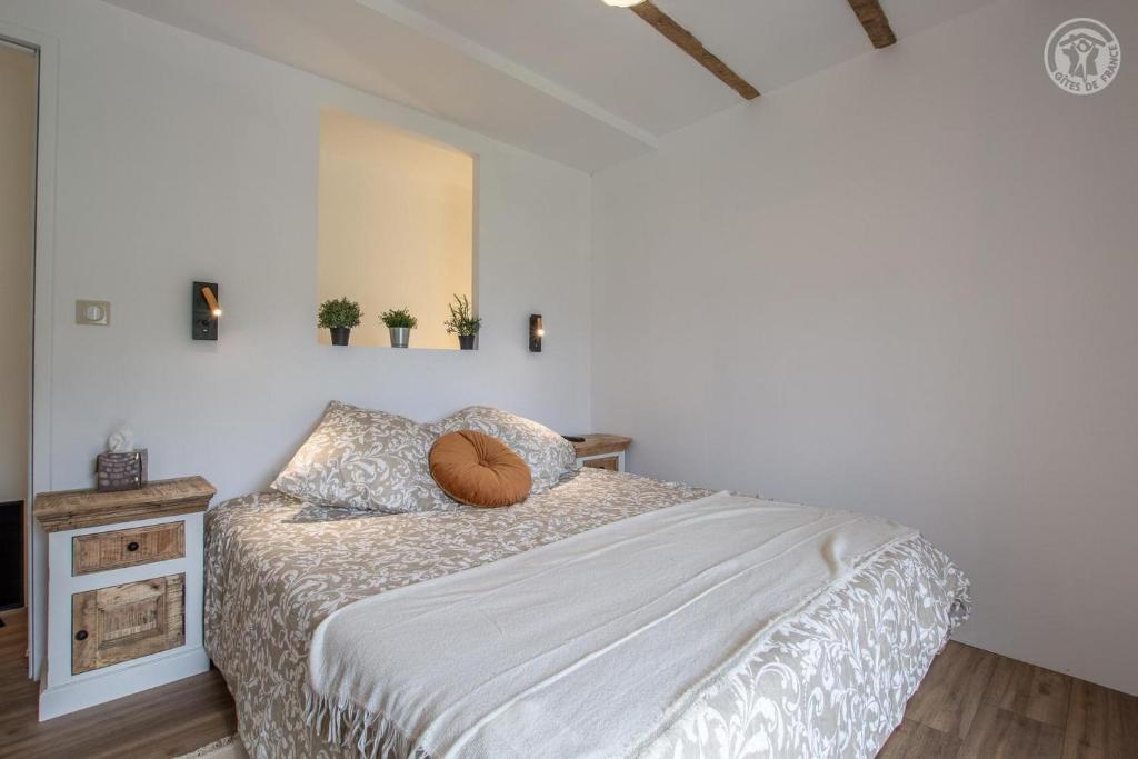 - une chambre avec un lit et deux plantes sur le mur dans l'établissement Le pigeonier, à Aix-les-Bains